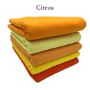 Stack of folded fabric in various orange and yellow shades on a white background with 'Citrus' text.